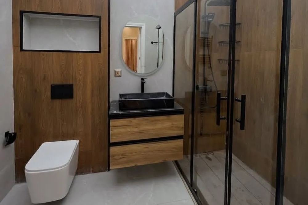 A bathroom with wood-effect panelling and a black-framed shower
