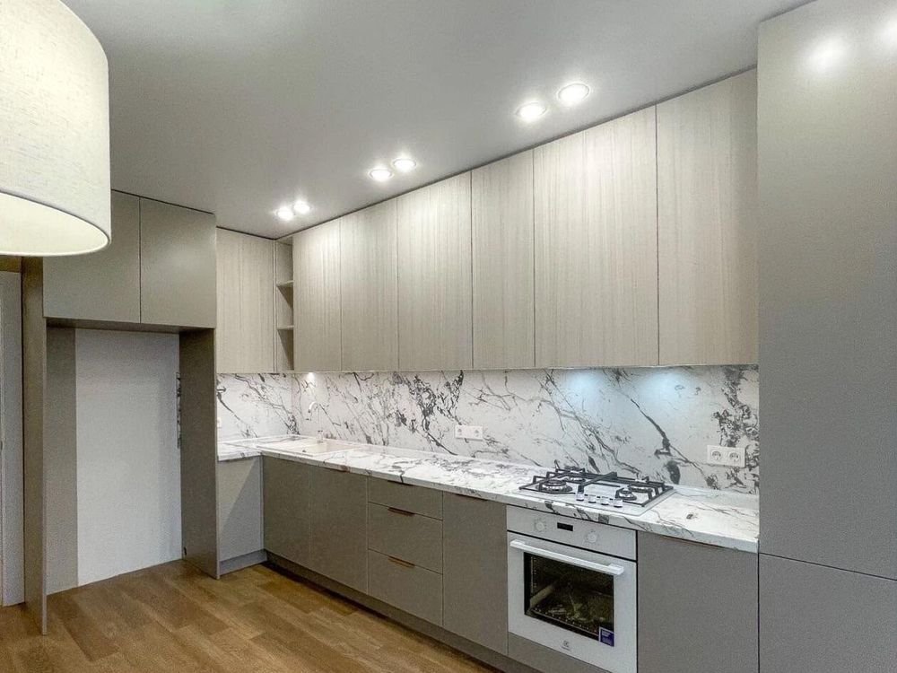A fitted kitchen with grey units and a marble worktop