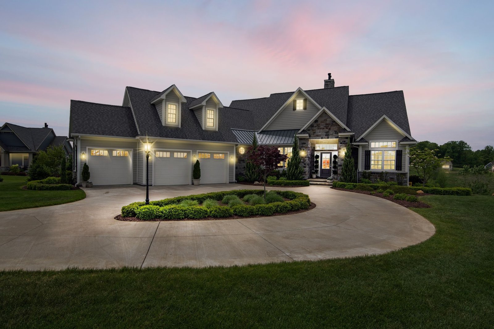 A large family house with lit windows at dusk