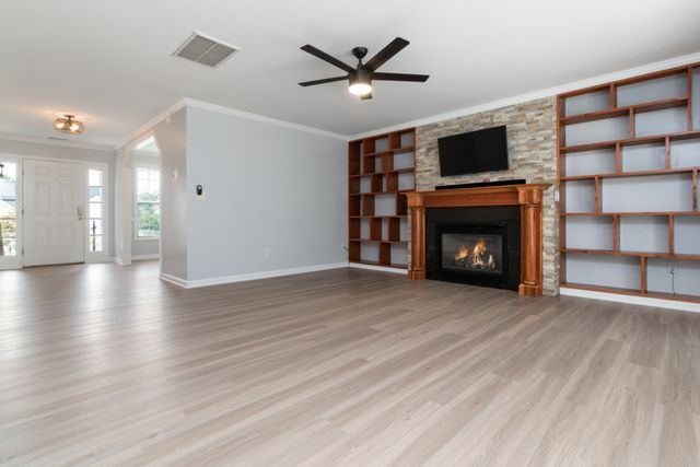 A living room with a stone fireplace and built-in shelving