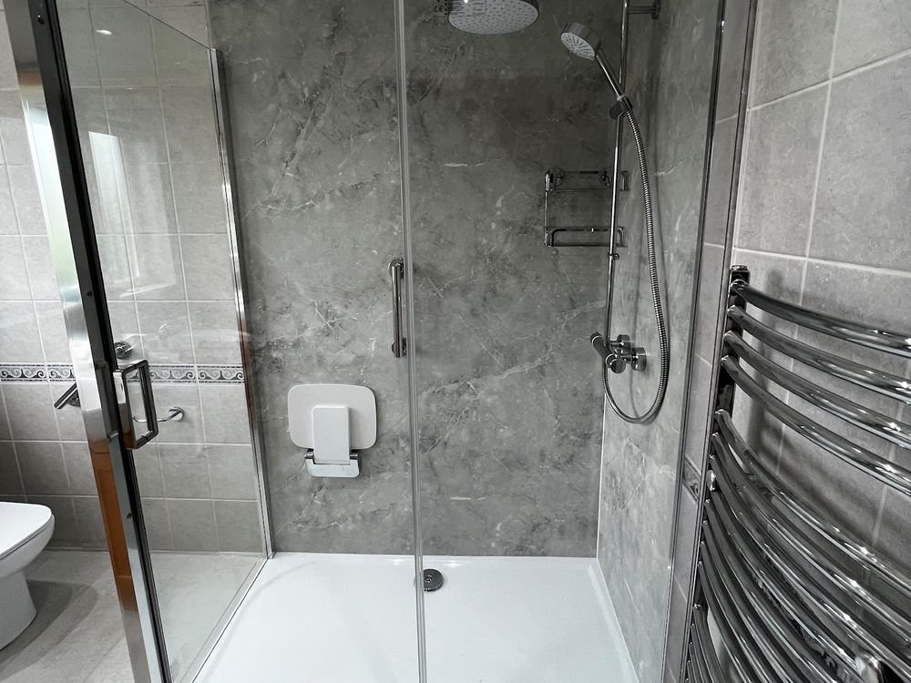 A tiled bathroom with a glass shower enclosure