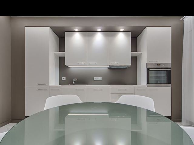 A white fitted kitchen with built-in oven and extractor