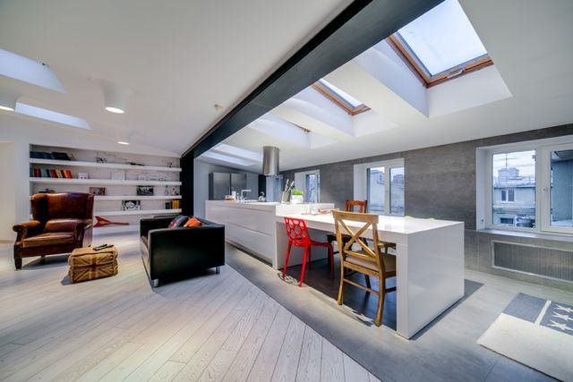An open-plan loft with roof windows, a kitchen island and a sitting area